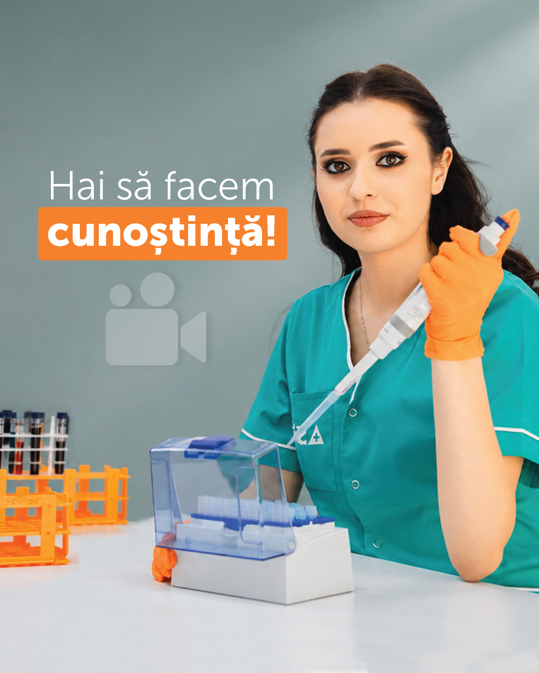 Asistentă medicală în halat verde, cu mănuși portocalii, ținând o seringă, lângă un echipament de laborator; textul 'Hai să facem cunoștință!' apare pe imagine cu o pictogramă video.