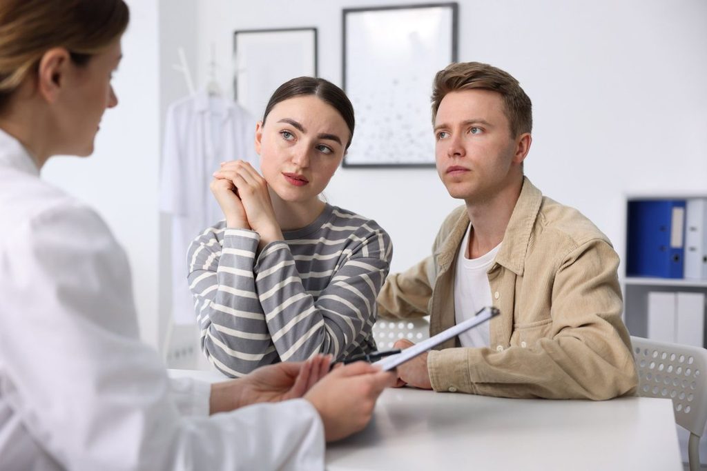 Cuplu într-un cabinet medical, discutând despre analizele recomandate înainte de sarcină